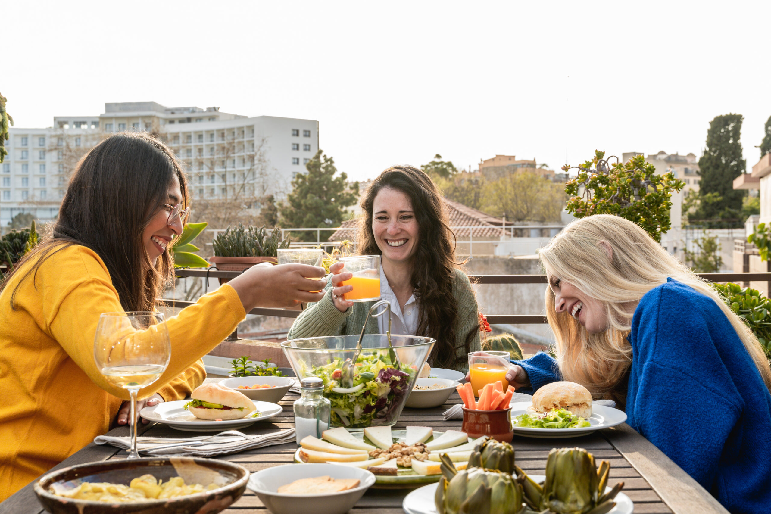Happy friends having fun drinking and eating vegan food outdoor – Focus on right girl face