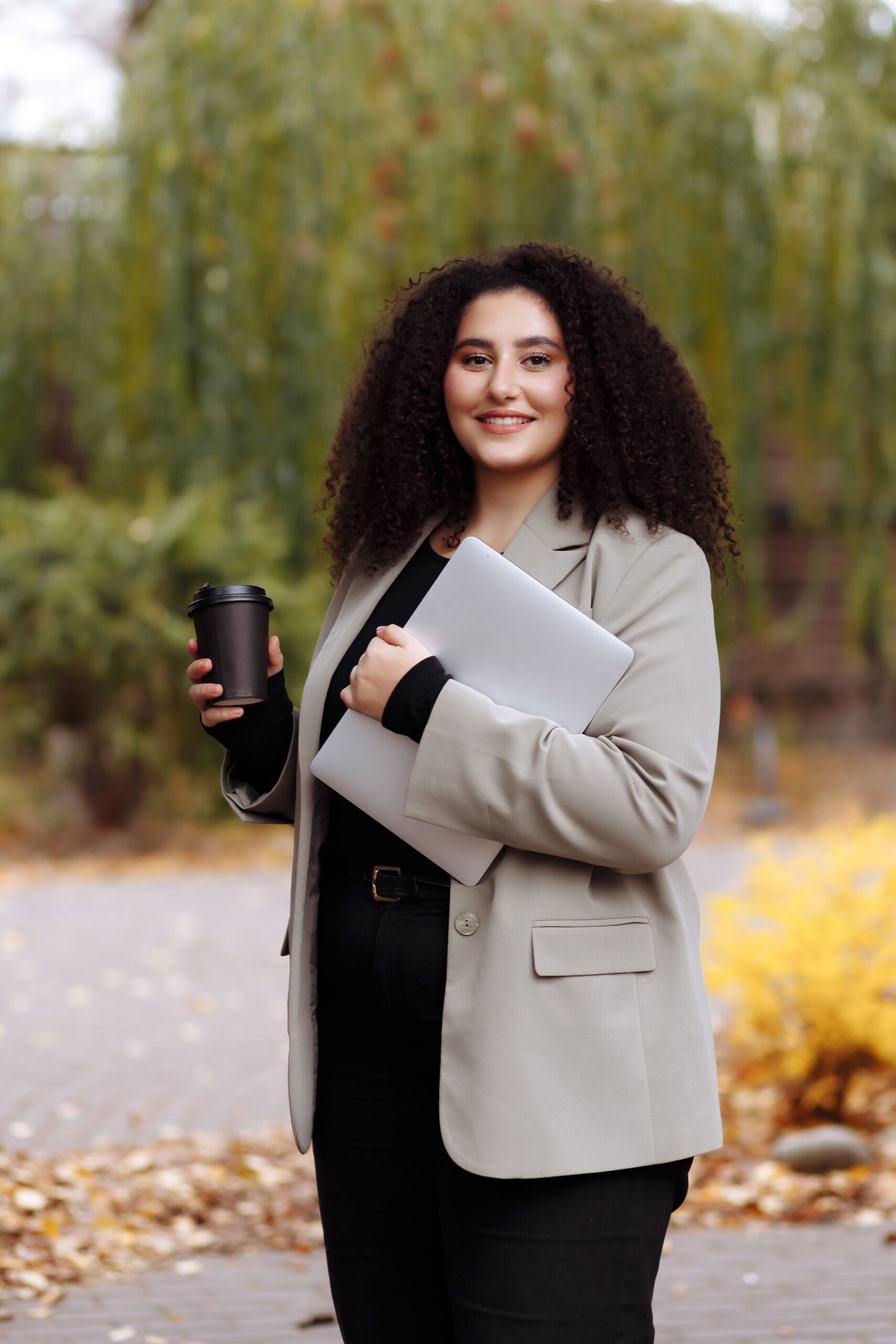 A business woman holds a glass of coffee in her hands